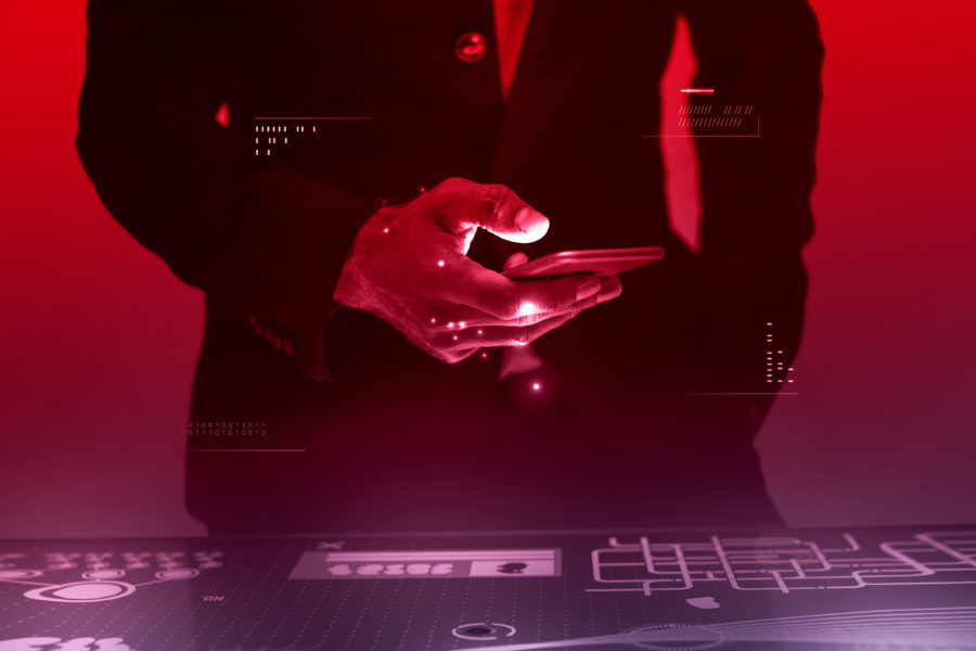 Man holding phone while looking at data on screen