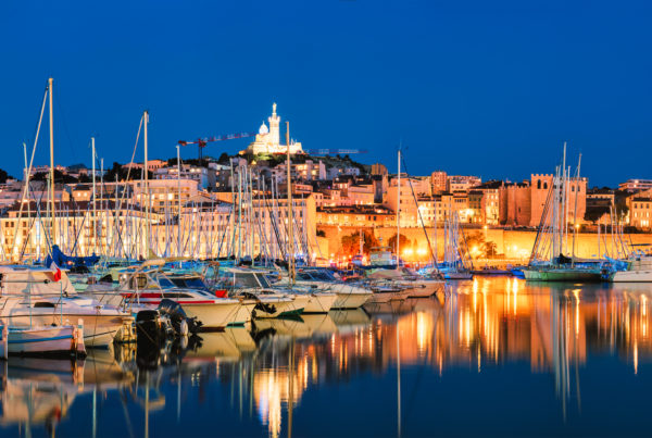 Panorama of Marseille Old Port (Vieux-Port de Marseille) with yachts and Basilica of Notre-Dame de la Garde in the night. Marseille, France